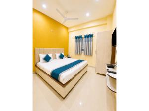 a bedroom with a bed and a television in it at HOTEL MEDHYA GRAND Near Goḏawalia Chauraha - 200 Meter From Baba Vishwanath Temple & Ganga Arti Ghat ! Wi-Fi #Lift #Hygiene & Spacious Room - BEST HOTEL IN VARANASI in Varanasi