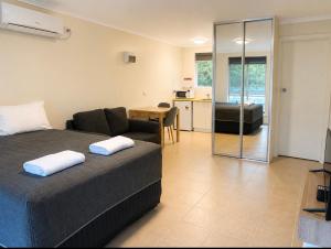 a bedroom with a bed and a living room at Robe Sunset Apartments in Robe