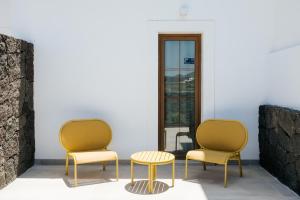 two chairs and a table in a room at Villa La Genuina in Yaiza +34 photos