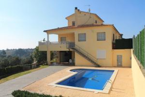 a villa with a swimming pool in front of a house at Villa Claudia in Lloret de Mar