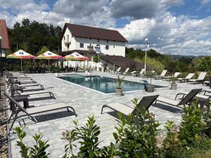a swimming pool with lounge chairs and umbrellas at Rem Garden in Novaci-Străini