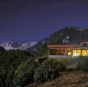 a house sitting on top of a mountain at night at Olympus Refuge D in Litochoro
