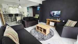 a living room with a couch and a table at Logement des palmiers in Flic-en-Flac