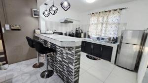 a kitchen with a counter and a refrigerator at Logement des palmiers in Flic-en-Flac