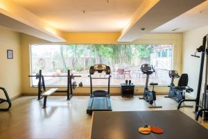 a gym with cardio equipment and a large window at Inventree Hotel Pune in Pune
