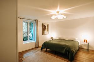 a bedroom with a bed and a ceiling fan at La Parenthèse Maisonneuve in Troyes