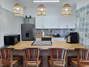a kitchen with a large wooden table with chairs at The Wave House on the Beach in Port Alfred +12 photos