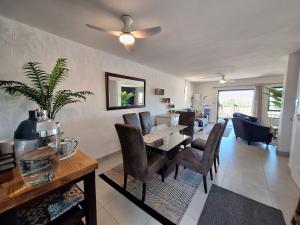 a dining room and living room with a table and chairs at The Wave House on the Beach in Port Alfred