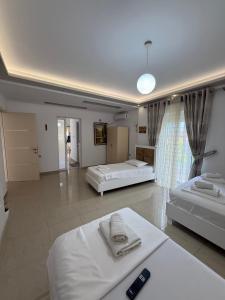 a large room with two beds and a large window at Ksamil Guest House Dea in Ksamil