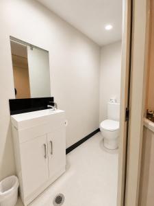 a white bathroom with a sink and a toilet at Aura Hotel in Wellington +16 photos