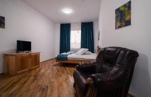 ein Wohnzimmer mit einem Ledersessel und einem Bett in der Unterkunft Abigarrado in Rucăr + 31 Fotos