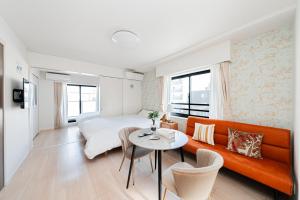 a room with a bed and a couch and a table at Maple Hotel Tokyo in Tokyo