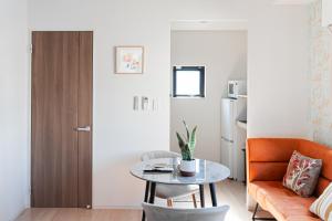 a living room with a table and a couch at Maple Hotel Tokyo in Tokyo