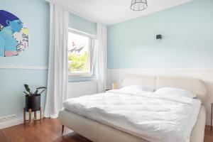 a bedroom with a white bed and a window at Willa Latarnik - doskonała lokalizacja, blisko atrakcji, 15min do plaży in Łeba