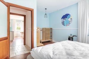 a bedroom with a bed and a blue wall at Willa Latarnik - doskonała lokalizacja, blisko atrakcji, 15min do plaży in Łeba