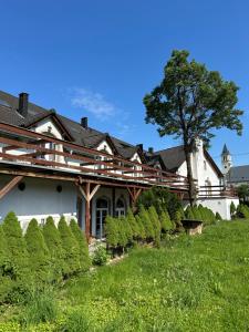 a white house with a tree in the yard at Viktorjan in Raszowa