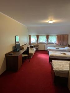 a hotel room with two beds and a desk at Viktorjan in Raszowa