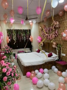 ein Schlafzimmer mit rosa und weißen Luftballons und einem Bett in der Unterkunft Hotel De Agya in Ludhiana
