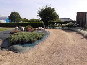 a garden with some plants on a dirt road at L'agapanthe in Plouézec