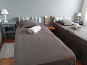 a bedroom with two beds and two tables and chairs at L'agapanthe in Plouézec