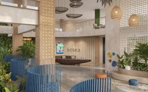 a lobby of a hotel with blue chairs and plants at Solea Azure Resort Panglao in Bingag