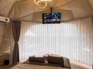 a living room with a couch and a tv on a tent at Zatura Dome Glamping in Panjadakan