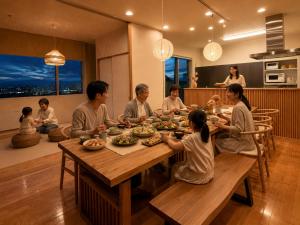 a group of people sitting around a table eating at Grand Opening SORA Yunokawa Penthouse in Hakodate