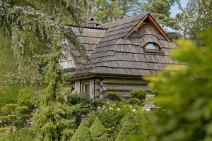 a log cabin with a shingled roof at Przystanek Zielnik in Łosie