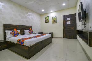 ein Schlafzimmer mit Bett und Flachbildfernseher in der Unterkunft Hotel De Agya in Ludhiana