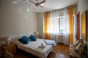 a bedroom with a bed with blue pillows and a window at A Casa Das Chocas in San Román