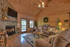 a living room with a fireplace in a log cabin at Squirrels Hideaway Fire Pit MTN Views in Copperhill