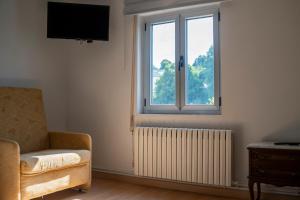 a living room with a window and a chair and a radiator at A Casa Das Chocas in San Román +38 photos