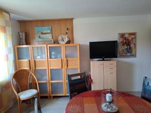 a living room with a tv and a table and a tv stand at Appartement auf dem Land in Neuenkirchen