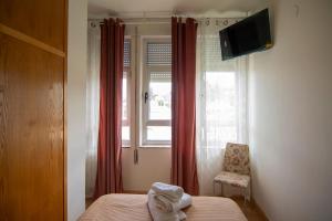 a bedroom with a bed and a window and a chair at A Casa Das Chocas in San Román