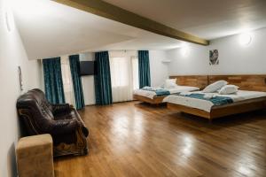ein Zimmer mit zwei Betten und einem Stuhl in der Unterkunft Abigarrado in Rucăr