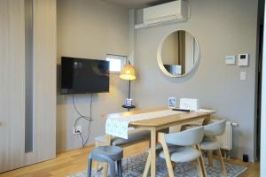 a dining room with a table and chairs and a mirror at Yukimi Hirafu in Niseko