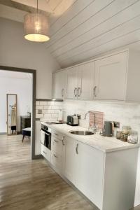 a kitchen with white cabinets and a sink at The Lodges @ Barra Castle in Inverurie