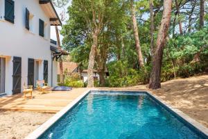 a swimming pool in a yard next to a house at Villa proche du lac d'Hossegor in Soorts-Hossegor