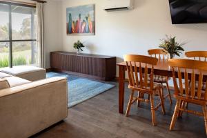 a living room with a table and chairs and a couch at Bayview Cabins Kangaroo Island in American River +5 photos