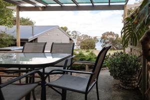 a table and chairs on a patio with a view at Bayview Cabins Kangaroo Island in American River
