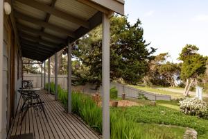 a covered porch with a table and chairs at Bayview Cabins Kangaroo Island in American River
