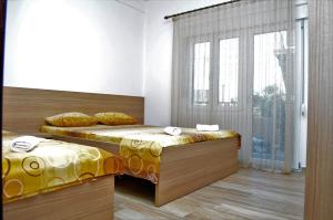 een slaapkamer met 2 bedden en een raam bij Apartments Md Lux 2 in Sutomore