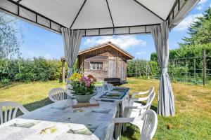 a table and chairs under a tent with a grill at Chez Daniel Et Zdenka in Villars-les-Dombes