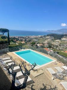 a swimming pool with chairs and a view of the ocean at Villa Gaia in Bordighera