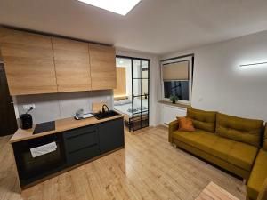 ein Wohnzimmer mit Sofa und eine Küche in der Unterkunft CUTE FLAT centrum in Suwałki