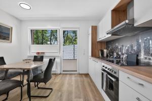 a kitchen with a table and chairs and a dining room at Suite Stadtgrün in Papenburg