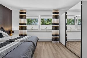 a bedroom with a bed and two windows at Suite Stadtgrün in Papenburg