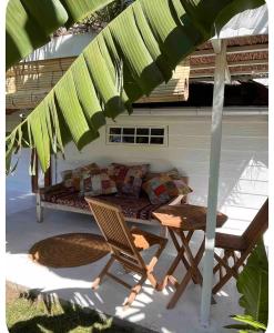 a patio with a couch and a table and an umbrella at Atunumai in Temae +4 photos
