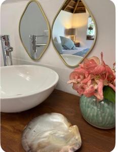 a bathroom with a sink and two mirrors on a counter at Atunumai in Temae