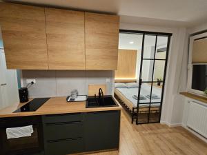 eine Küche mit Spüle und ein Bett in einem Zimmer in der Unterkunft CUTE FLAT centrum in Suwałki + 1 Foto